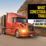 Smiling truck driver standing next to a red semi-truck pulling a Conestoga flatbed trailer with a sliding tarp system , showcasing a guide to smarter and more secure hauling solutions.