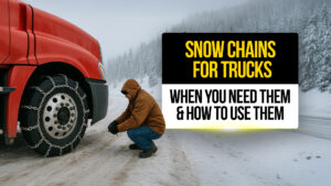 Truck driver installing snow chains on a red semi-truck tire in snowy mountain conditions, showing how and when to use tire chains for safe winter driving.