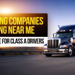 Graphic promoting “Trucking Companies Hiring Near Me” with a blue semi-truck on the road at sunset and a driver standing beside it; text reads “2026 Guide for Class A Drivers.”